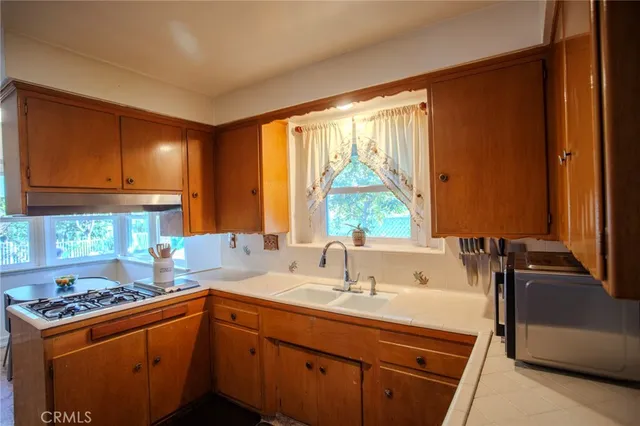 a kitchen with a sink stove and cabinets