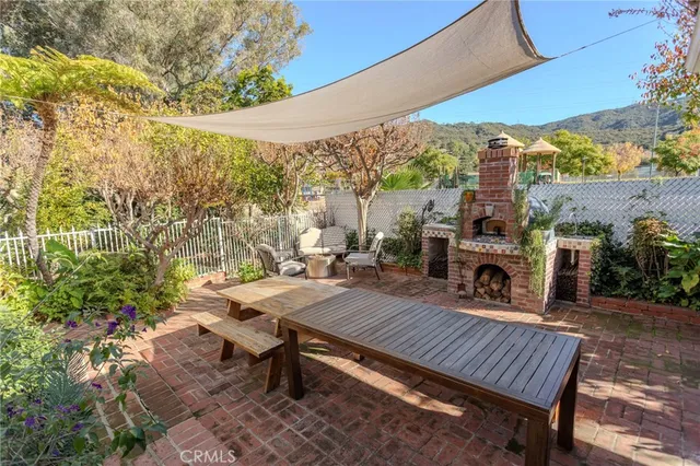 a view of a patio with table and chairs a barbeque with wooden fence