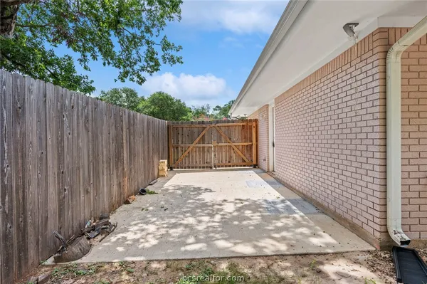 a view of backyard with wooden fence