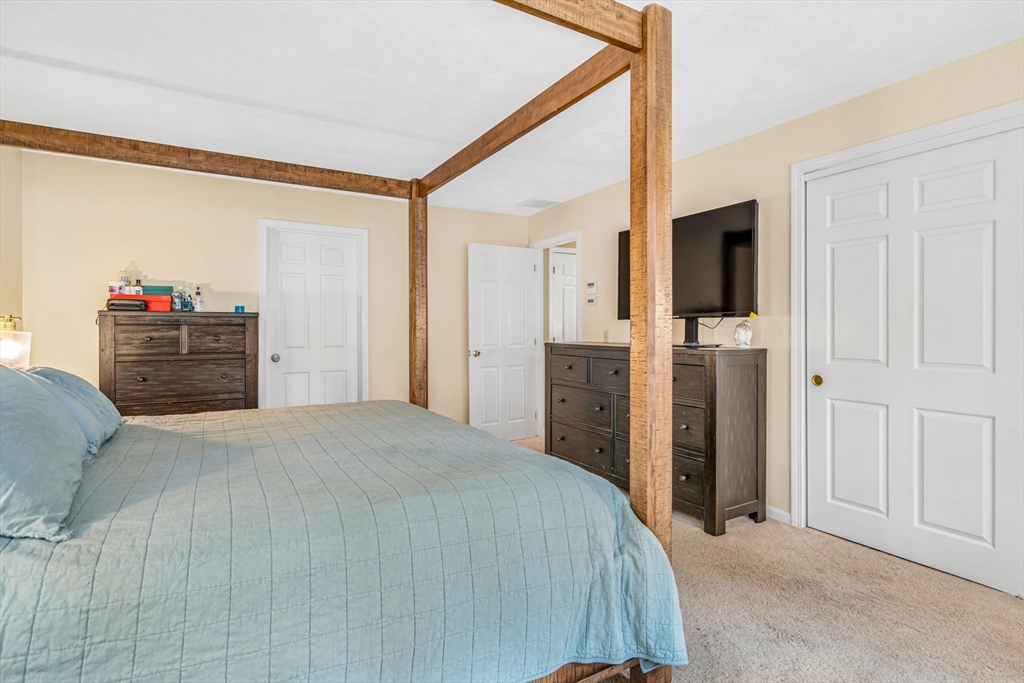11 Green Needles Road Littleton, MA 01460 - Photo 22 of 41 a bedroom with a bed and a flat tv screen