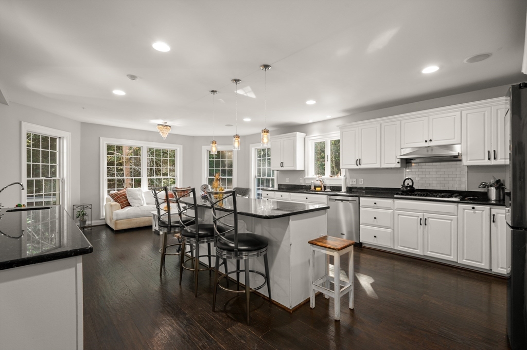 27 Turtle Back Road Essex, MA 01929 - Photo 6 of 40 a kitchen with stainless steel appliances granite countertop a stove top oven a sink dishwasher a dining table and chairs with wooden floor