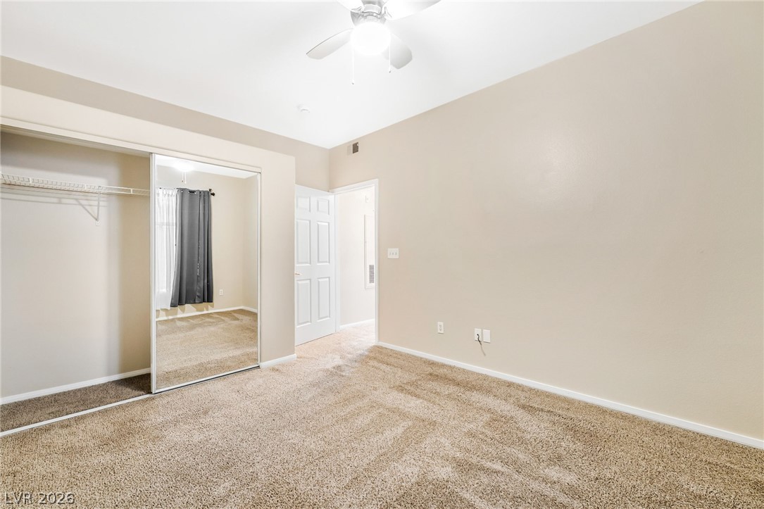2050 West Warm Springs Road, Unit 2411 Henderson, NV 89014 - Photo 29 of 37 A well-lit bedroom featuring a spacious closet with mirrored doors and plush carpet flooring.