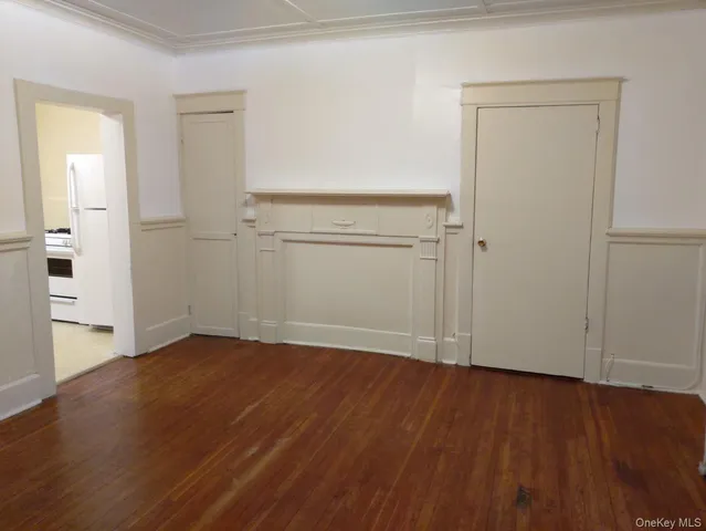 an empty room with wooden floor & closet and windows