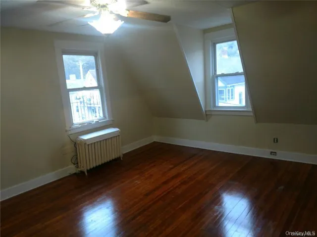 a view of a room with wooden floors and window
