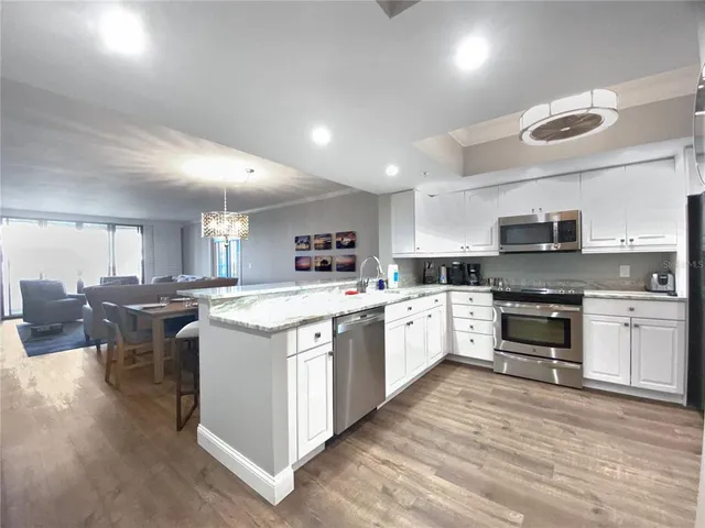 a large kitchen with stainless steel appliances granite countertop a stove and a sink