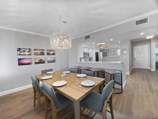a view of a dining room with furniture wooden floor and chandelier