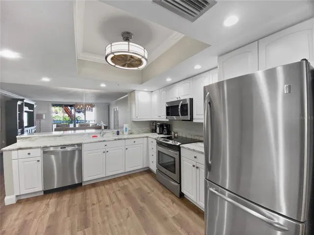 a large kitchen with stainless steel appliances granite countertop a stove and a refrigerator