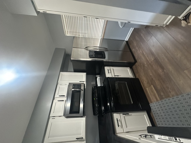 2215 Post Road, Unit 2044 Austin, TX 78704 - Photo 13 of 34 Gleaming hardwood floors and classic shaker cabinetry define this functional kitchen workspace.