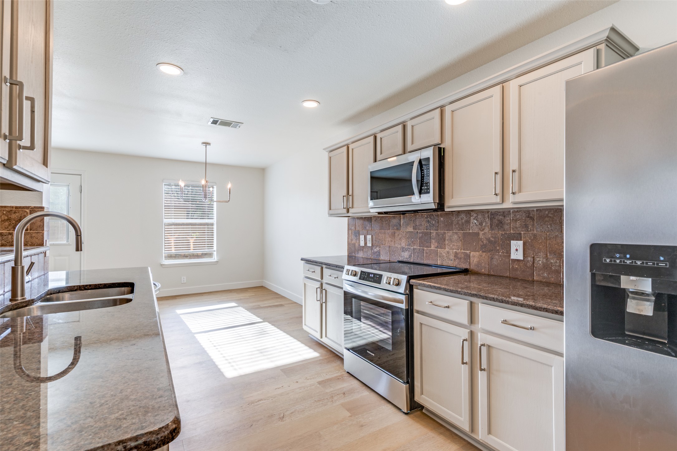 109 Orange Tree Lane Georgetown, TX 78626 - Photo 11 of 25 a kitchen with granite countertop a stove sink and microwave