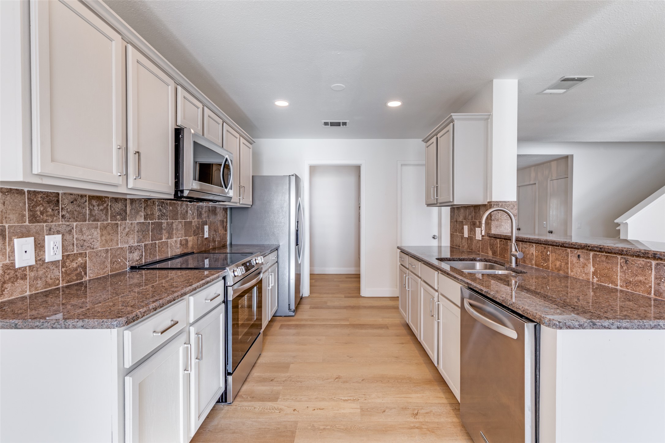 109 Orange Tree Lane Georgetown, TX 78626 - Photo 9 of 25 a kitchen with stainless steel appliances granite countertop a sink stove microwave and cabinets
