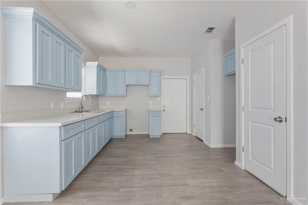 340 Eva Street, Unit 2 Elsa, TX 78543 - Photo 4 of 12 a kitchen with white cabinets