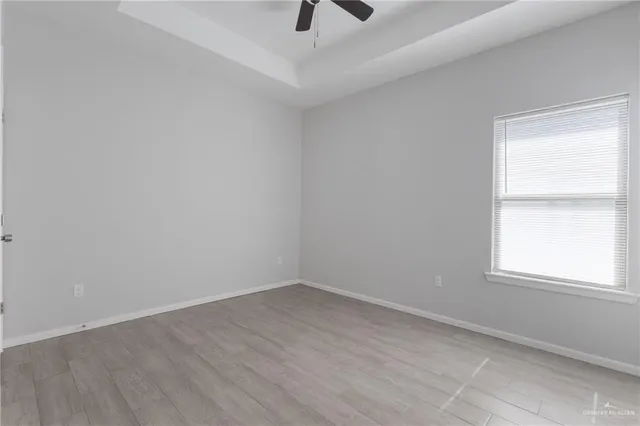 an empty room with a window and a ceiling fan