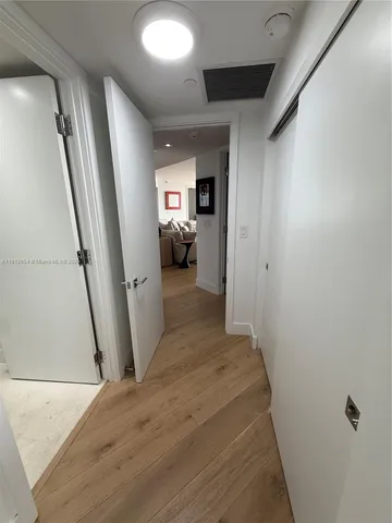 a view of a hallway with workspace and a window