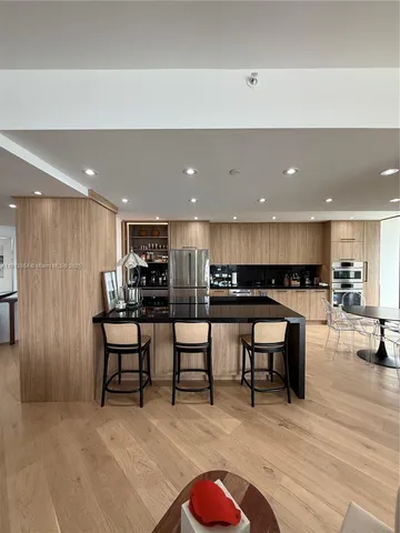 a kitchen with stainless steel appliances kitchen island granite countertop a sink and cabinets