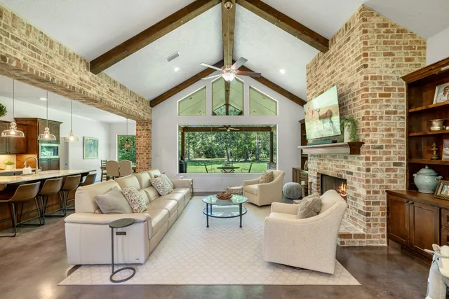 a living room with fireplace furniture and a large window