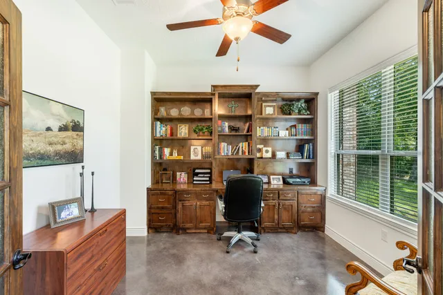 a view of a workspace with furniture and a window