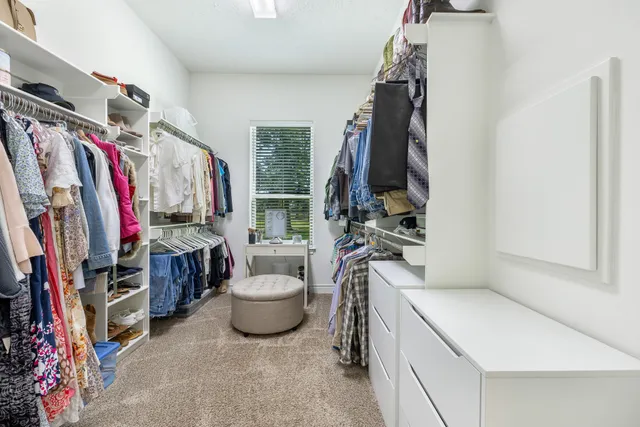 a view of walk in closet with clothes and shoes