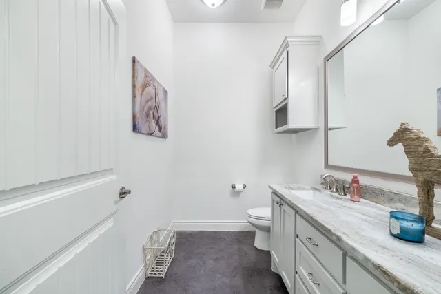 a bathroom with a granite countertop sink toilet and vanity