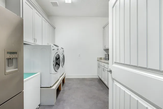 a utility room with cabinets washer and dryer