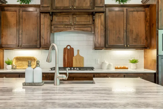 a kitchen with stainless steel appliances granite countertop a refrigerator and a stove top oven