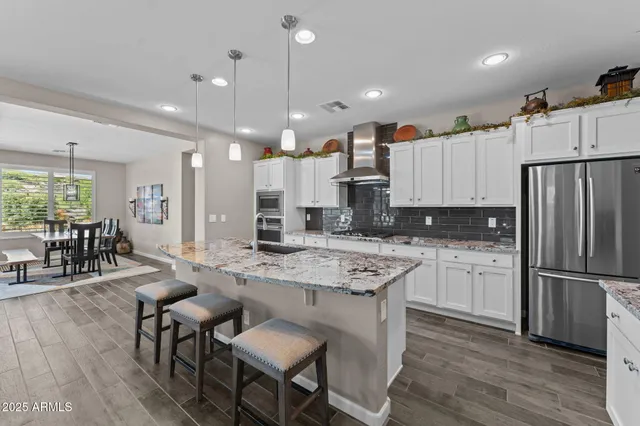 a large kitchen with kitchen island a dining table and chairs