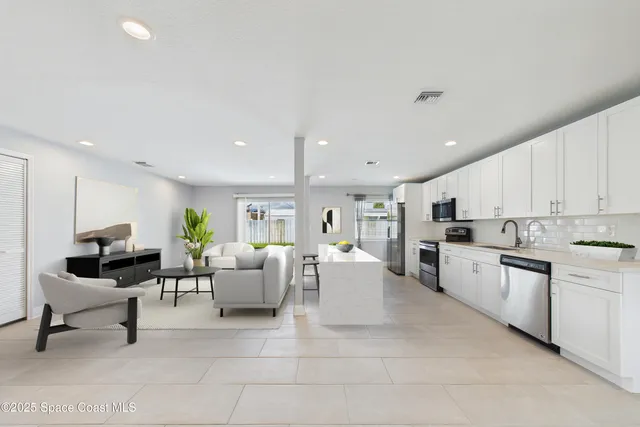 an empty room with a kitchen and stainless steel appliances