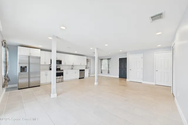 a living room with stainless steel appliances kitchen island granite countertop furniture and a view of kitchen