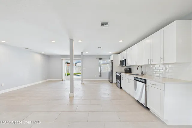a view of an empty room with kitchen