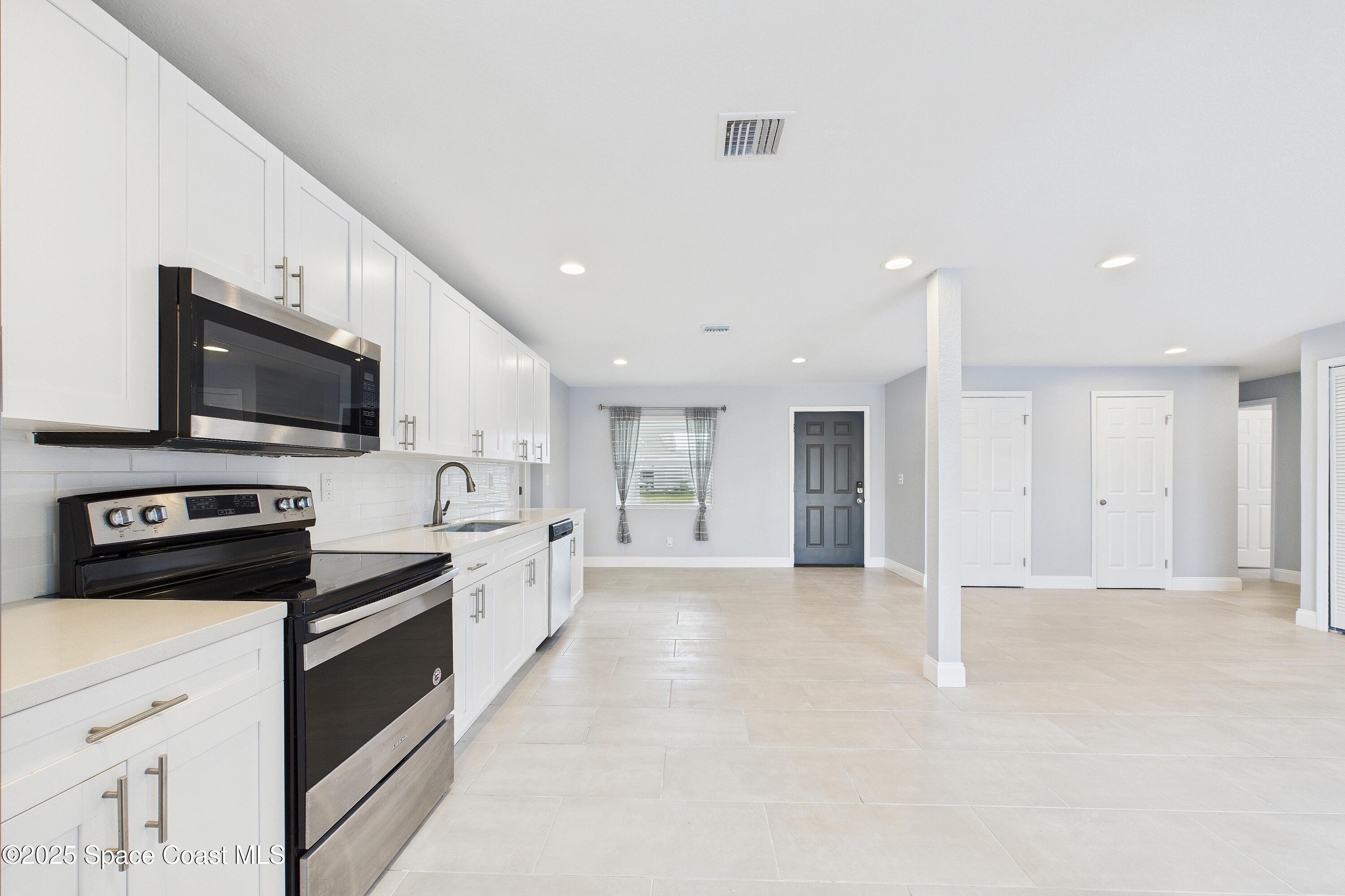 1500 Dorsal Street Merritt Island, FL 32952 - Photo 21 of 56 a large kitchen with stainless steel appliances granite countertop a stove and a sink
