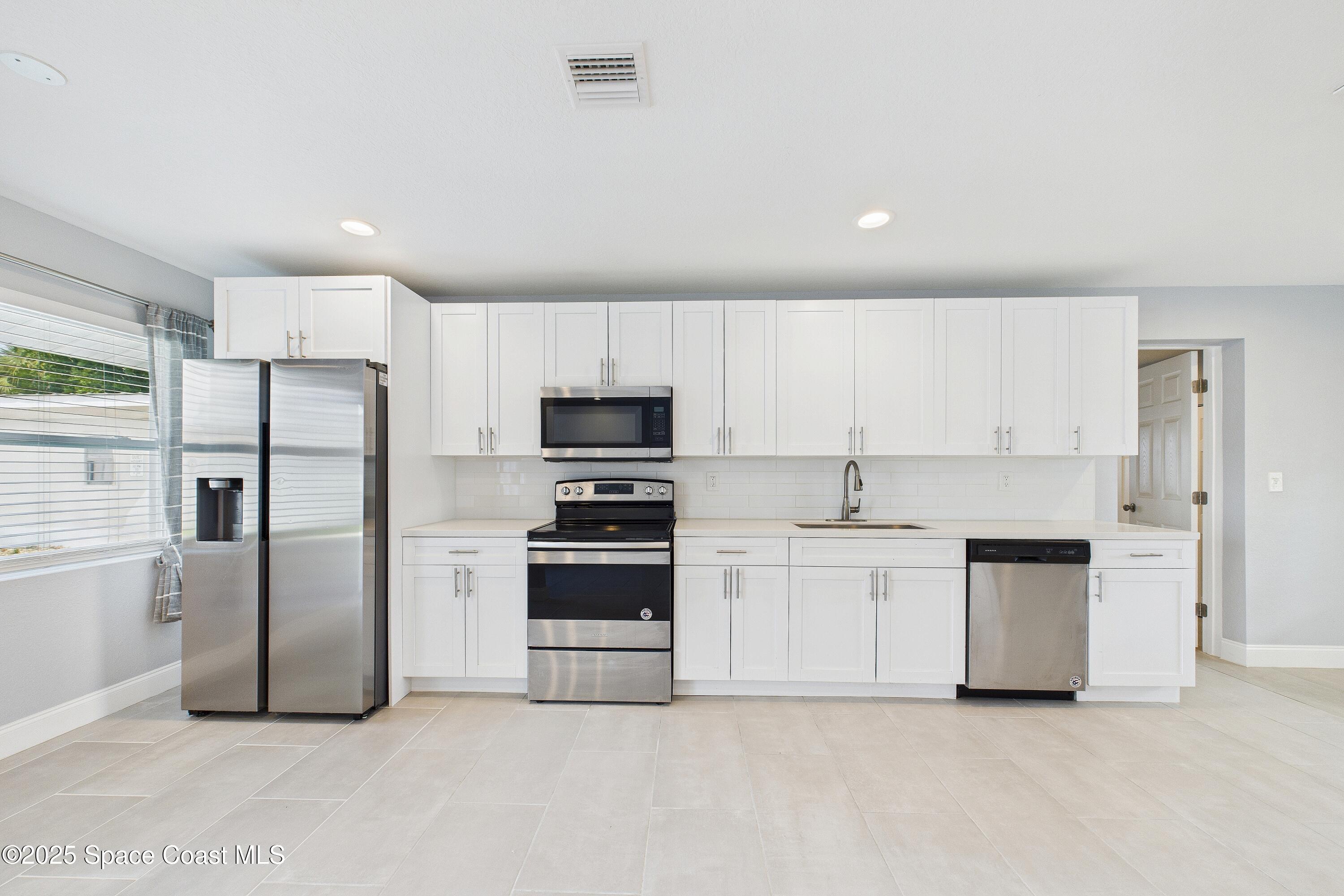 1500 Dorsal Street Merritt Island, FL 32952 - Photo 24 of 56 a kitchen with stainless steel appliances a refrigerator sink and white cabinets