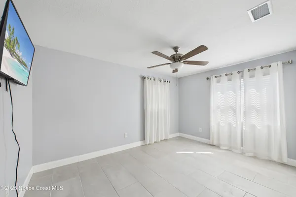 a view of a livingroom with a ceiling fan and window