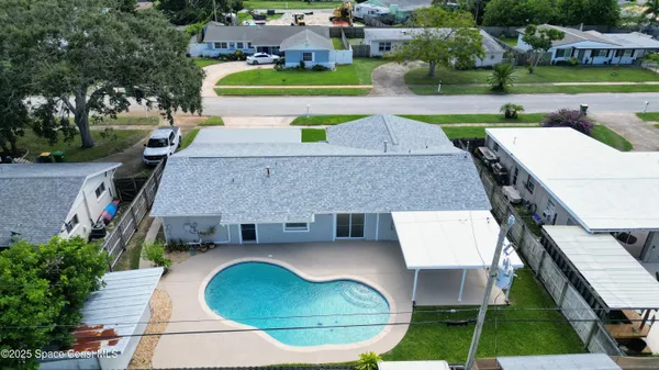 an aerial view of a house with swimming pool and patio