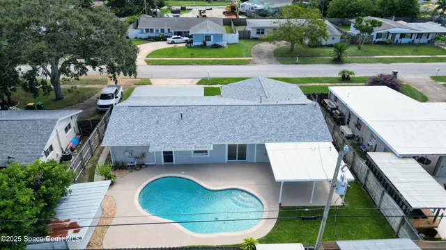 an aerial view of a house with swimming pool and patio