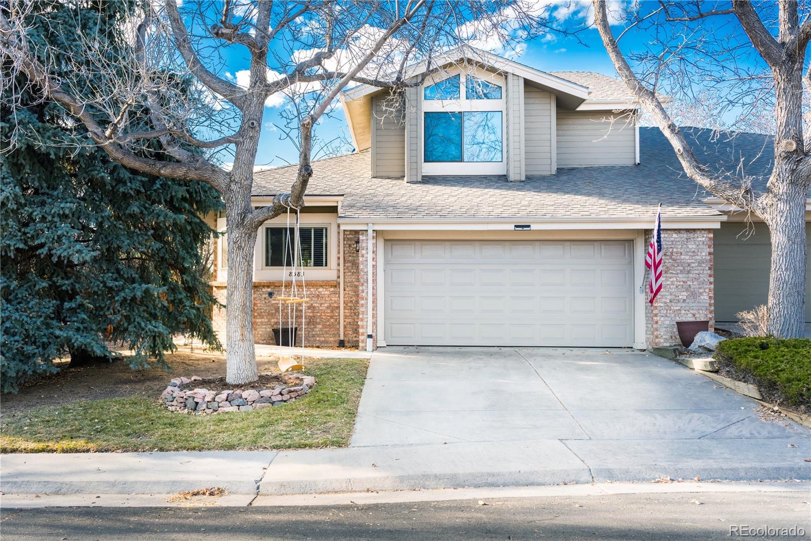 a front view of a house with a garden and trees
