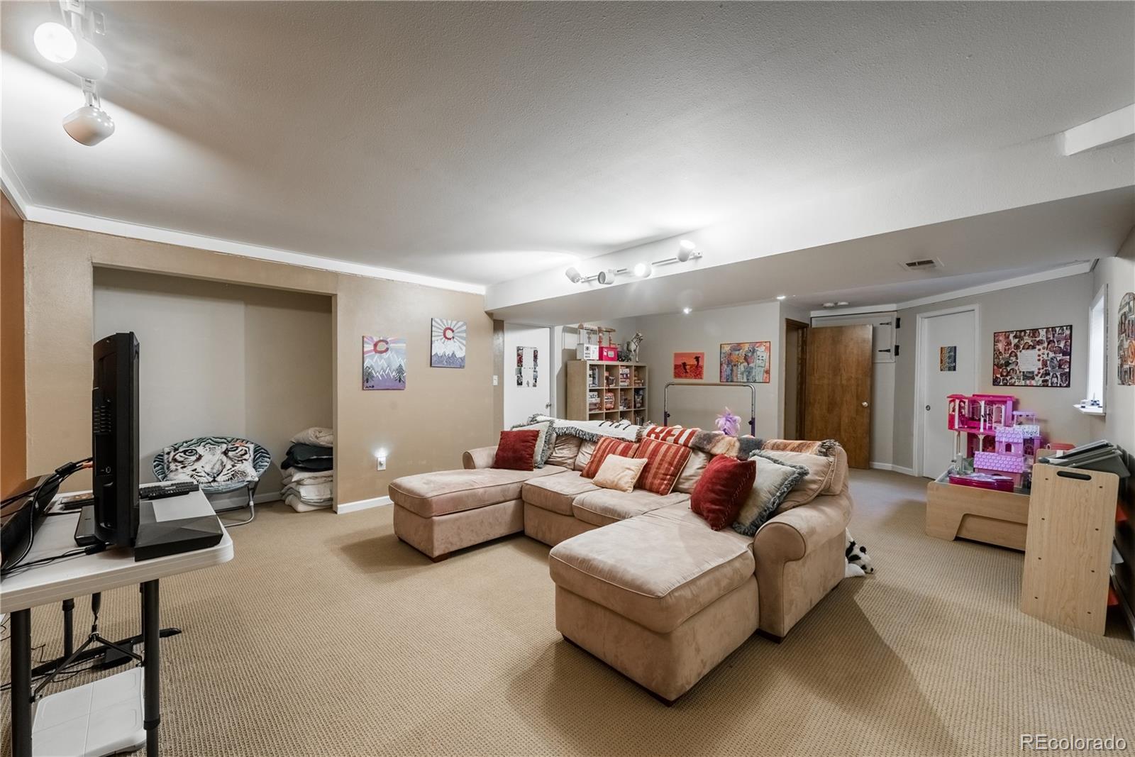 8583 Redstone Street Highlands Ranch, CO 80126 - Photo 16 of 25 a living room with furniture and a flat screen tv