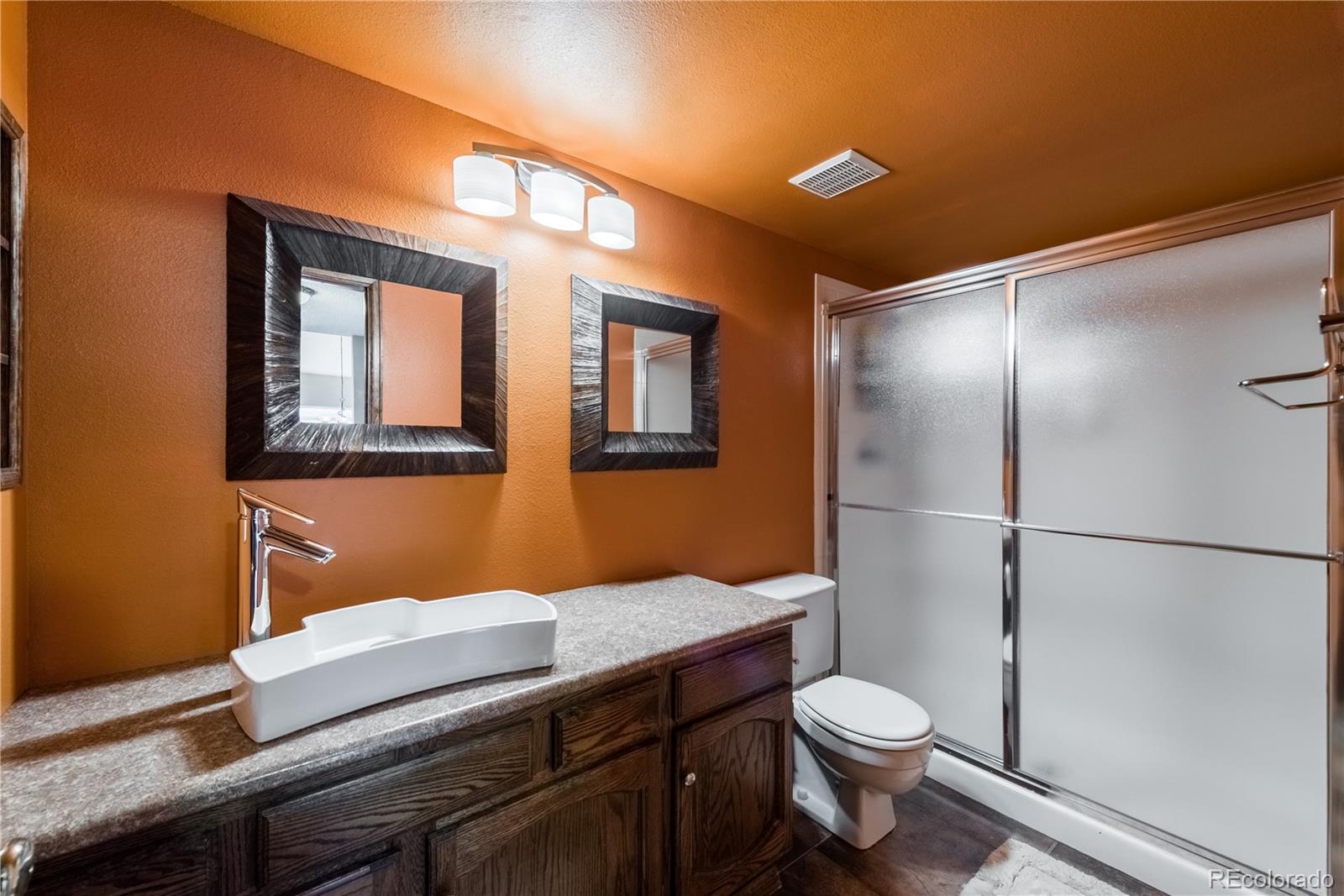 8583 Redstone Street Highlands Ranch, CO 80126 - Photo 17 of 25 a bathroom with a toilet a sink and mirror