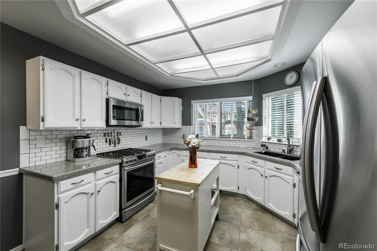8583 Redstone Street Highlands Ranch, CO 80126 - Photo 4 of 25 a kitchen with stainless steel appliances granite countertop a sink window and cabinets
