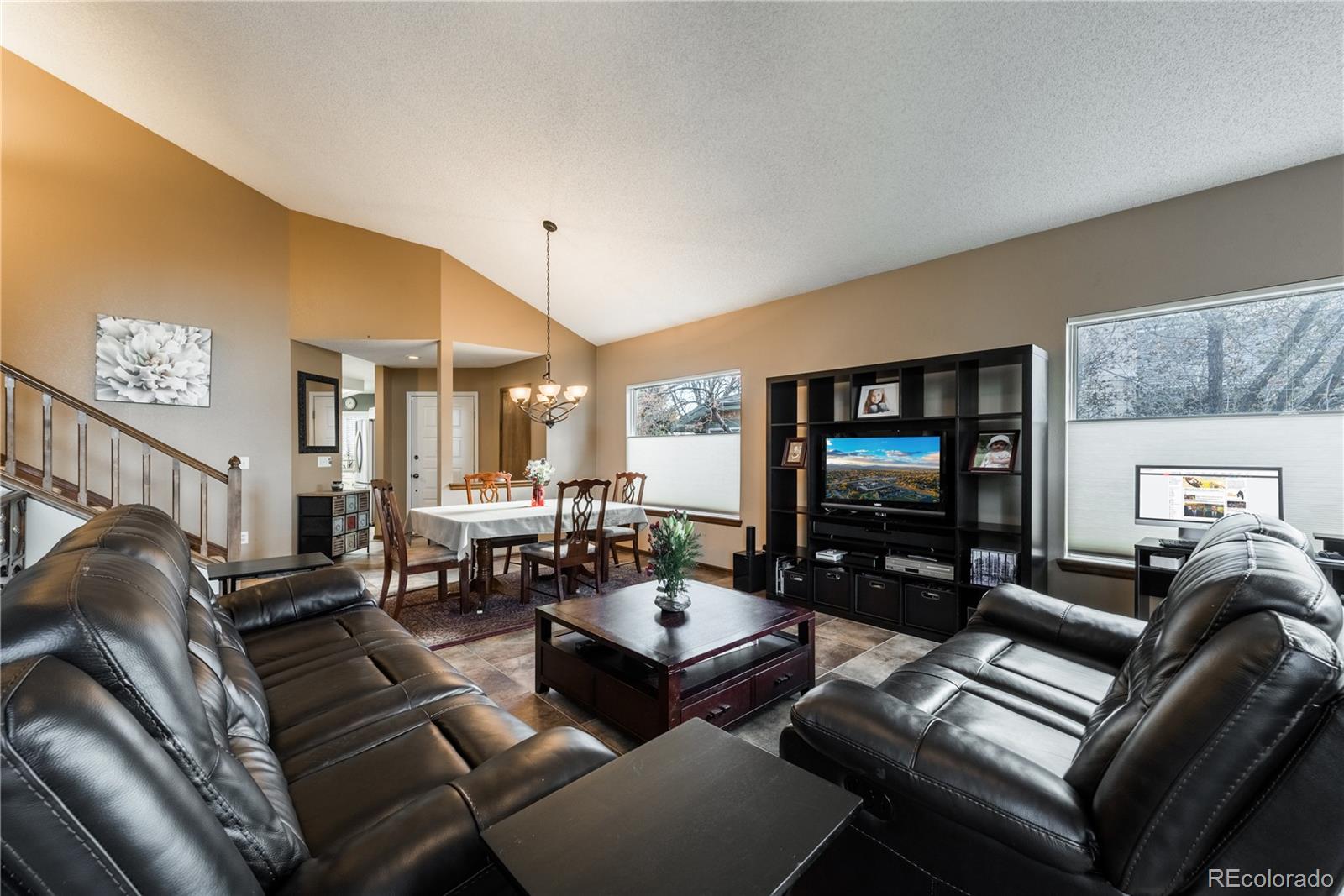 8583 Redstone Street Highlands Ranch, CO 80126 - Photo 8 of 25 a living room with furniture and a flat screen tv