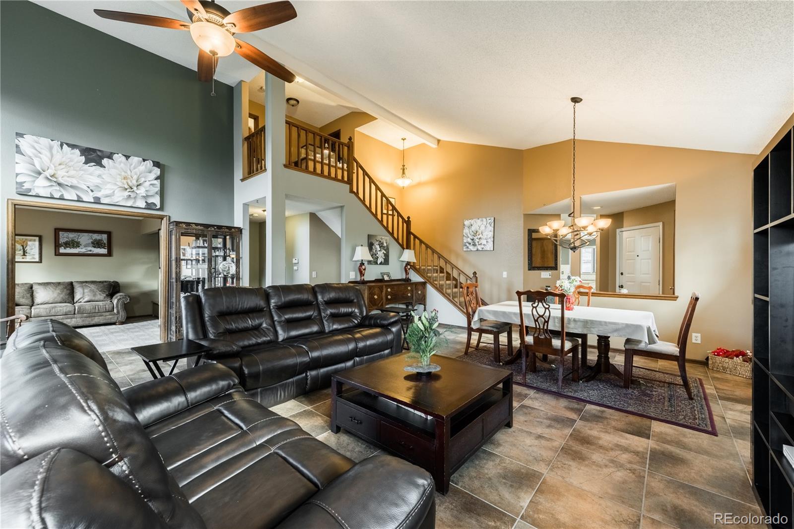 8583 Redstone Street Highlands Ranch, CO 80126 - Photo 10 of 25 a living room with furniture a dining table and chairs