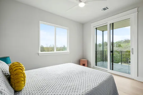 an empty room with windows and fan