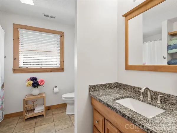 a bathroom with a granite countertop sink and a mirror