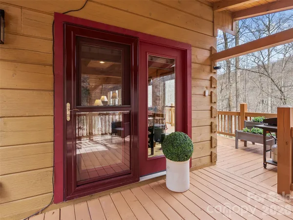 a view of a porch with wooden floor and floor to ceiling window