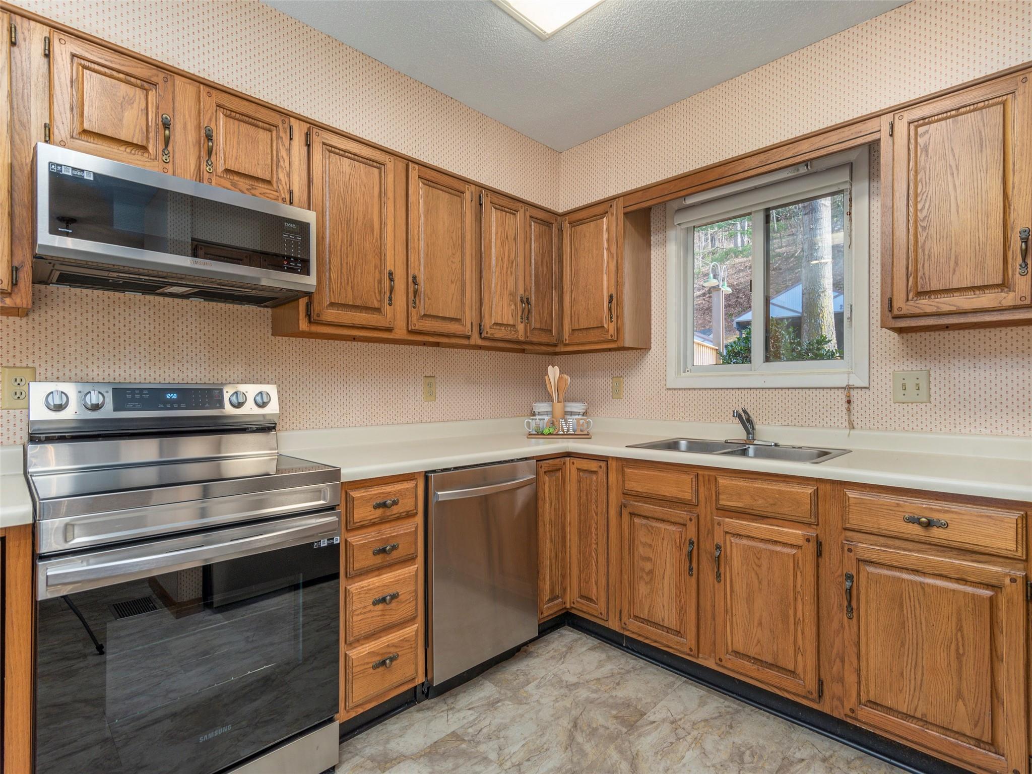 87 Willow Road, Unit A2 Waynesville, NC 28786 - Photo 8 of 29 a kitchen with stainless steel appliances granite countertop a stove microwave and sink