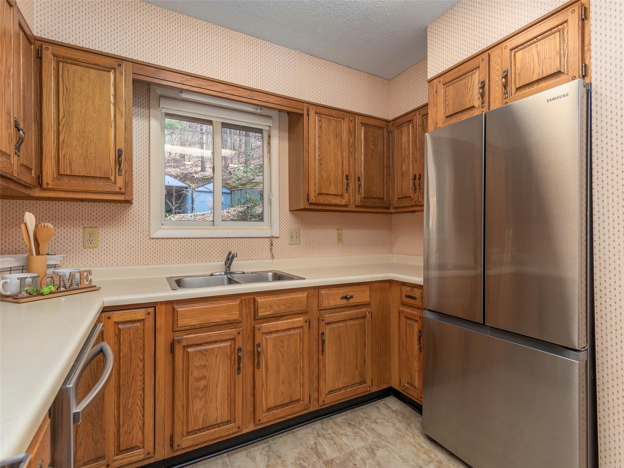 87 Willow Road, Unit A2 Waynesville, NC 28786 - Photo 9 of 29 a kitchen with a refrigerator sink and cabinets