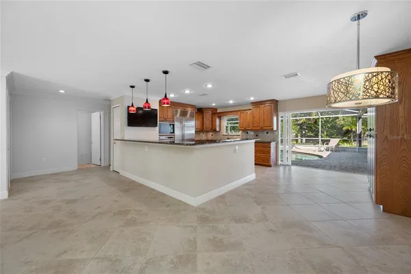 a view of a kitchen with kitchen island stainless steel appliances counter space and a window