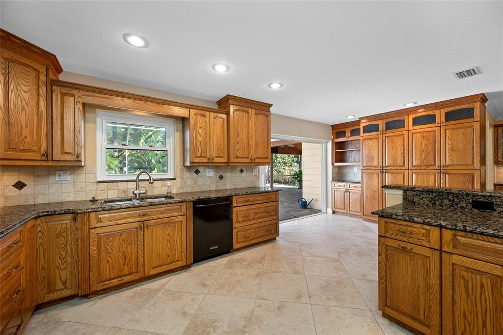 5473 97th Way North St. Petersburg, FL 33708 - Photo 17 of 57 a kitchen with granite countertop a sink stove and cabinets