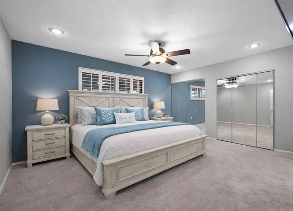 a spacious bedroom with a bed and a chandelier
