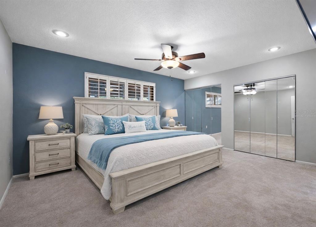 5473 97th Way North St. Petersburg, FL 33708 - Photo 26 of 62 a spacious bedroom with a bed and a chandelier