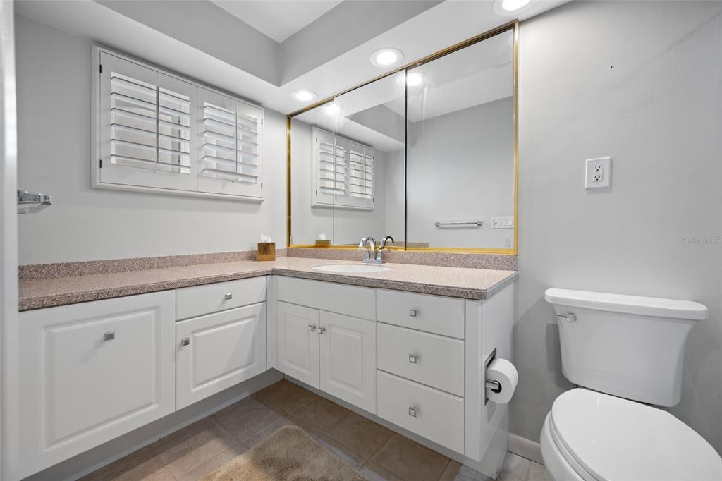 5473 97th Way North St. Petersburg, FL 33708 - Photo 27 of 57 a bathroom with a toilet a sink a mirror a and a window