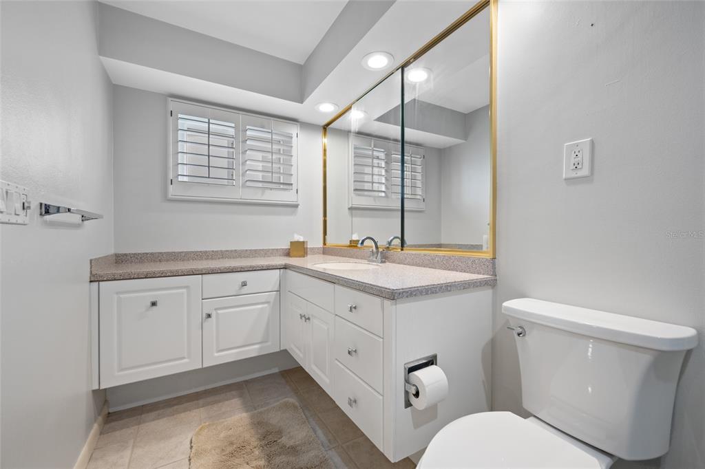 5473 97th Way North St. Petersburg, FL 33708 - Photo 31 of 62 a spacious bathroom with a granite countertop toilet sink and mirror